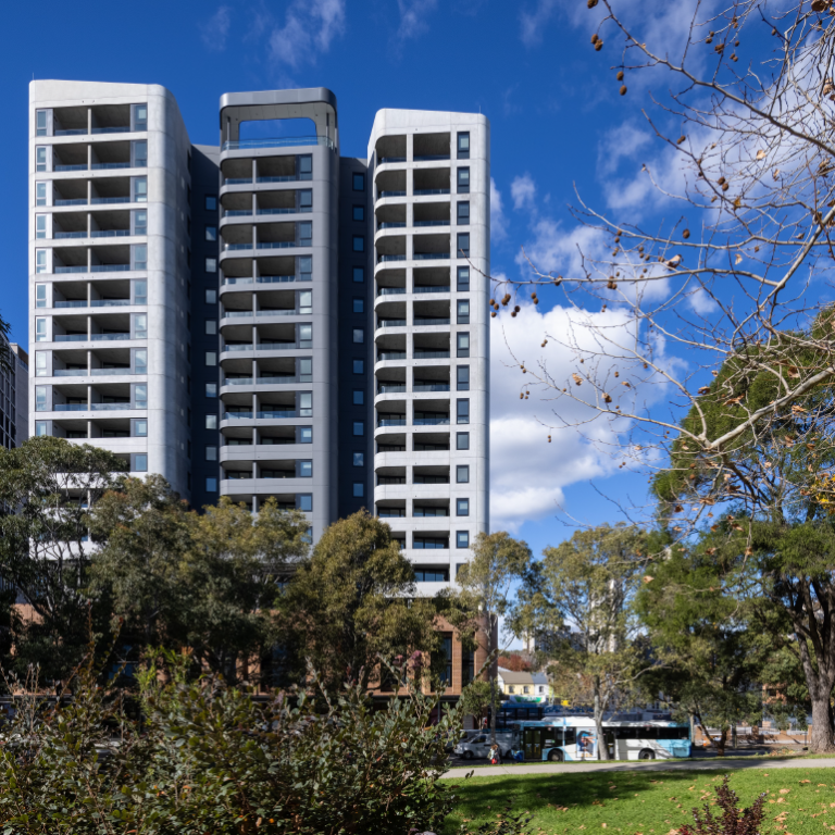 High rise apartment building shown through parkland