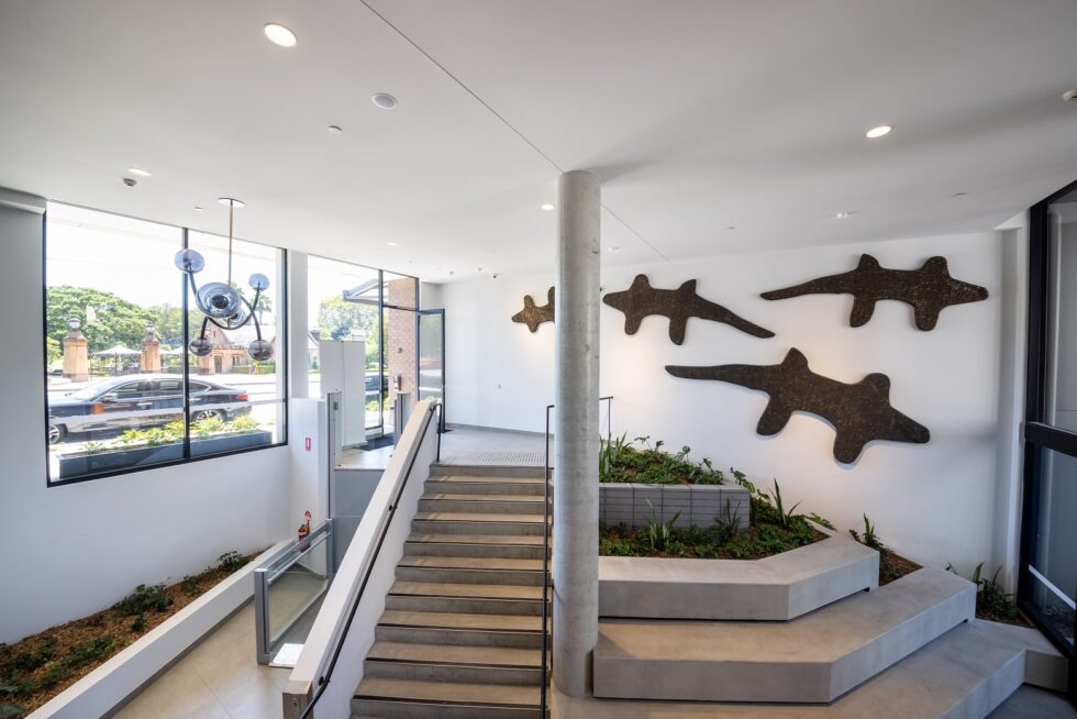 Bright foyer space with indoor gardens and large artwork
