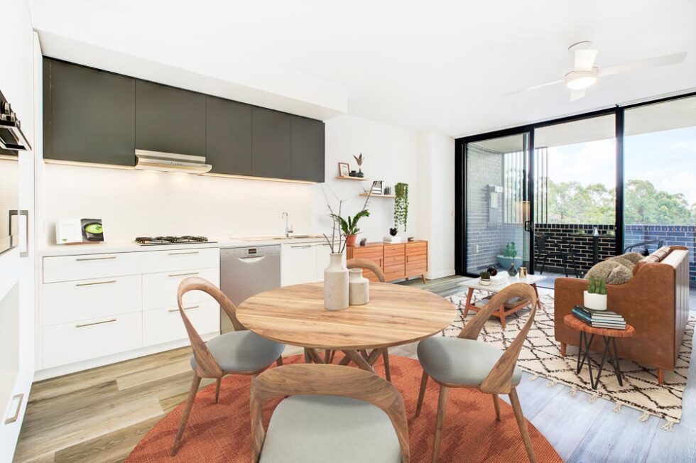 Kitchen and dining area of display furnished unit looking through lounge area to balcony