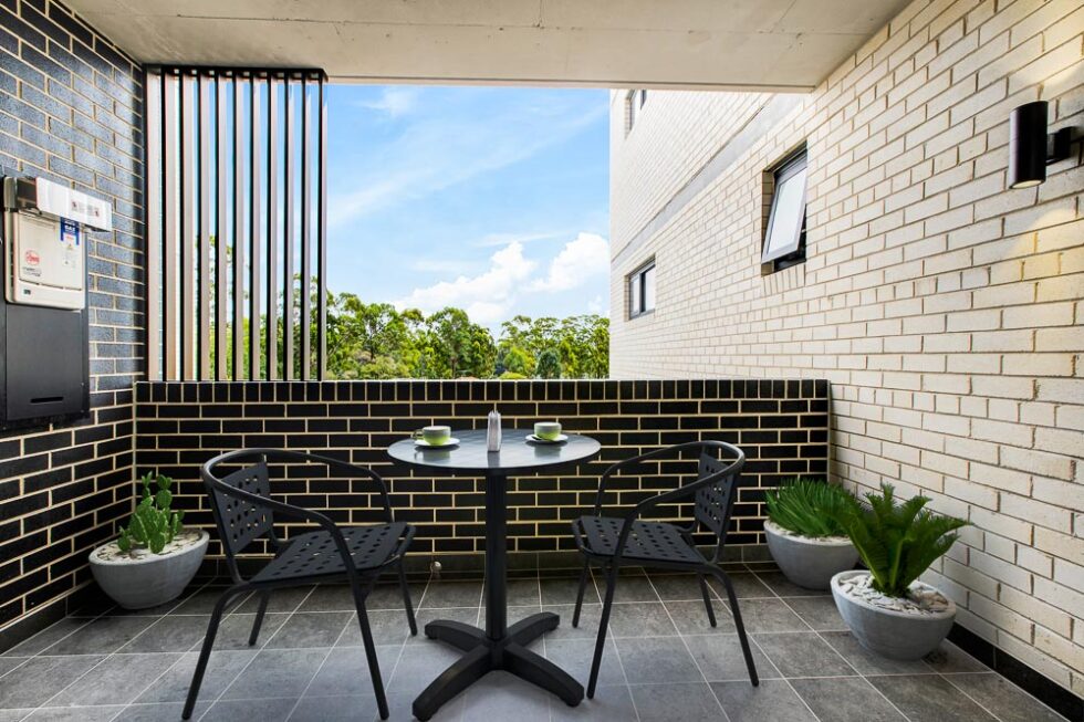 Display furnished balcony with outdoor table setting and view over the suburbs