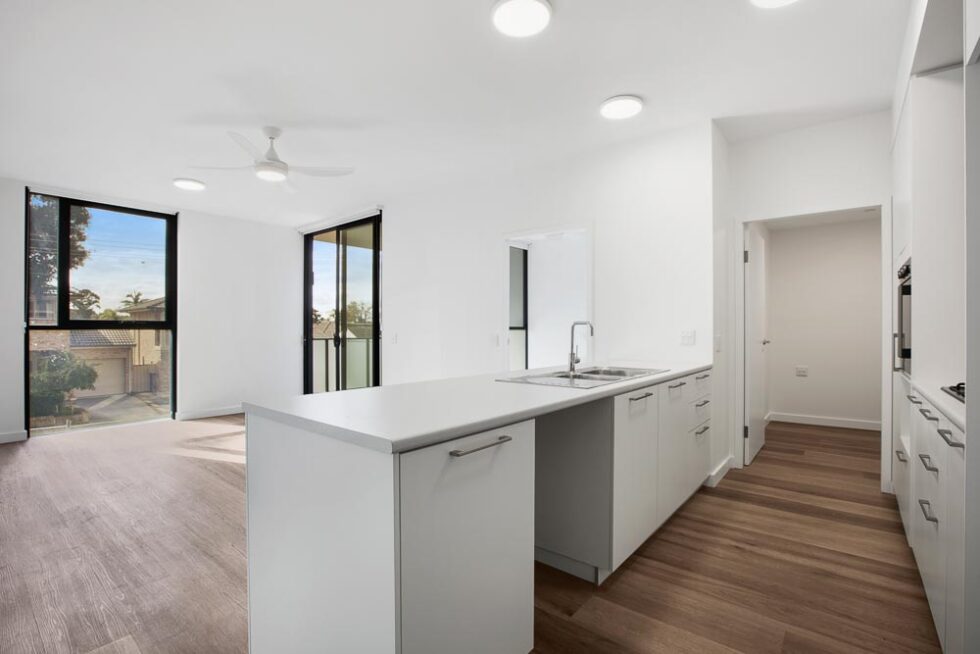 Kitchen and dining area of brightly lit unfurnished unit