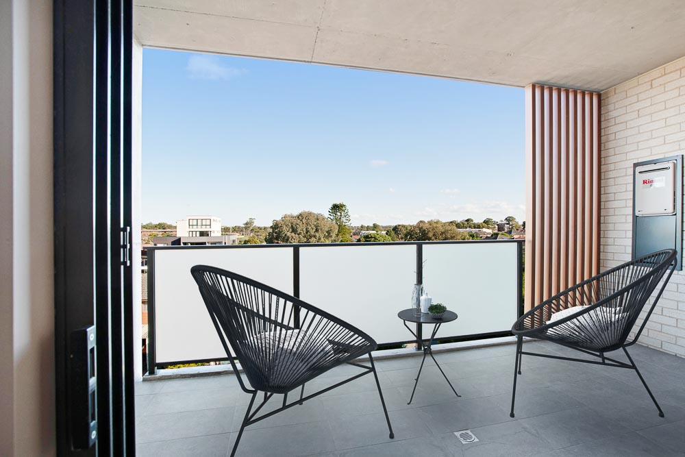 View from a balcony on a sunny day, with outdoor chairs