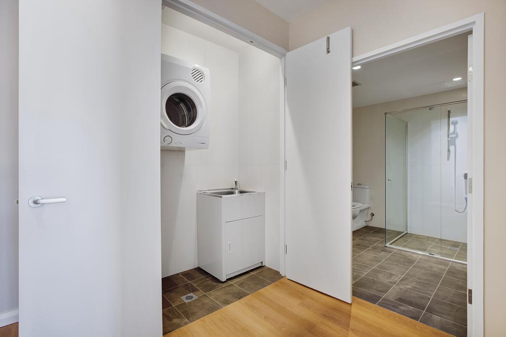 Adjacent entrances to separate bathroom and laundry rooms in new unit