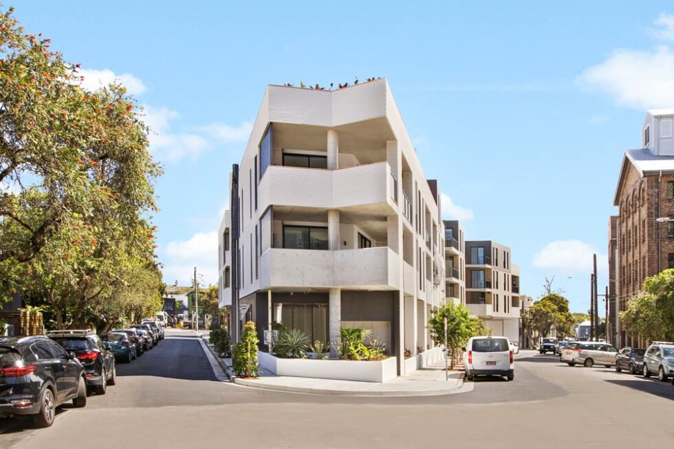 Three story white coloured building at the point of a triangle road