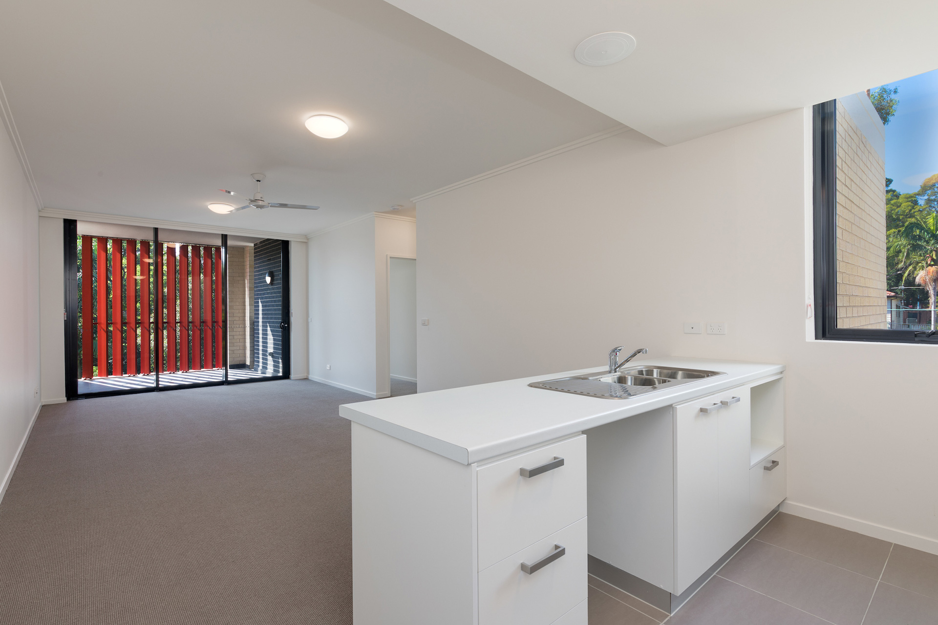 View from kitchen through to loungeroom and balcony of unfurnished unit