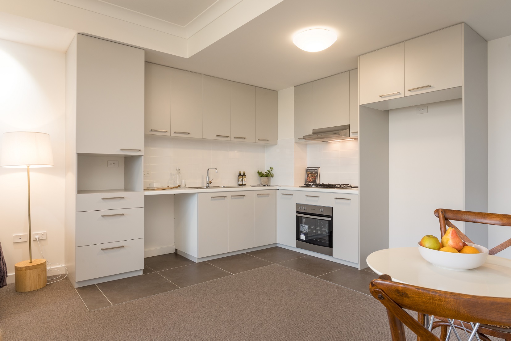Kitchen area of unit showing oven, and space for microwave and fridge