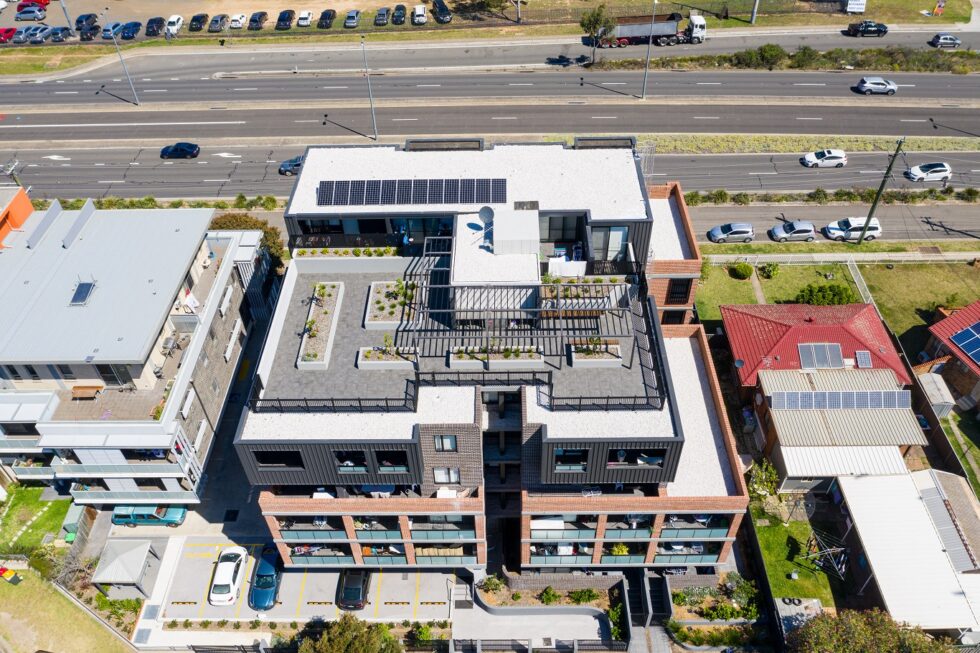 Aerial drone view of four storey building with rooftop gardens