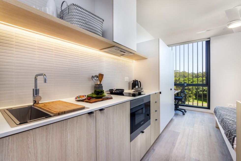 Kitchenette of studio apartment, looking through to sleep and study area