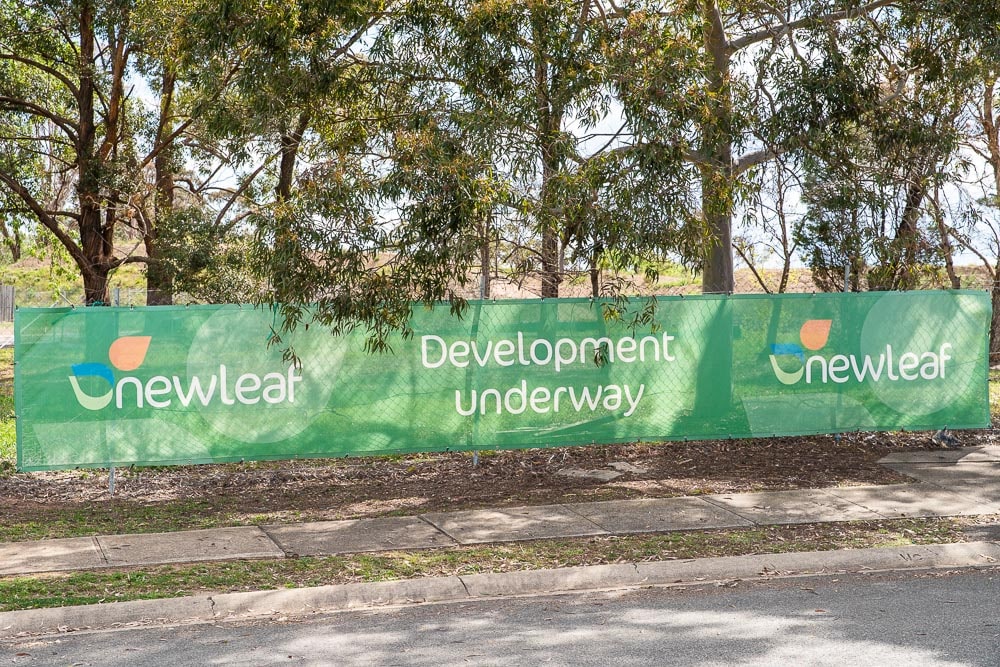 Sign that reads 'Newleaf, Development underway' with trees in the background