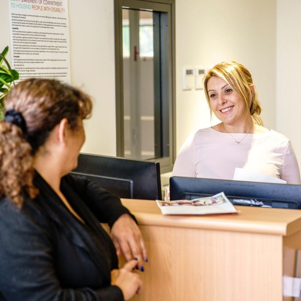 Smiling staff helping a customer at reception