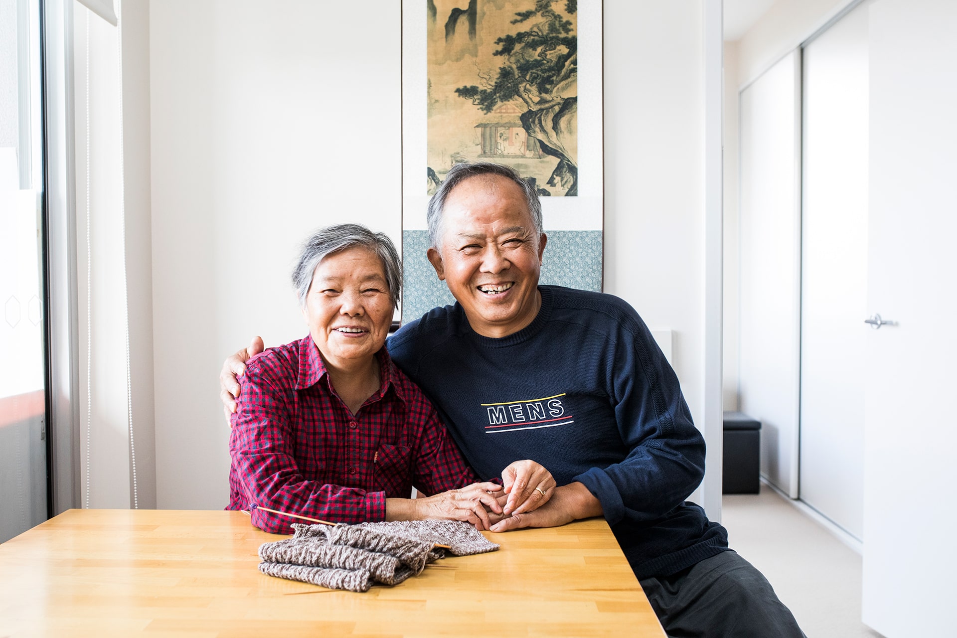 Smiling senior couple sitting at a table in their apartment