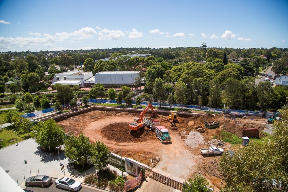 Aeriel view of a construction site with suburbs stretching behind