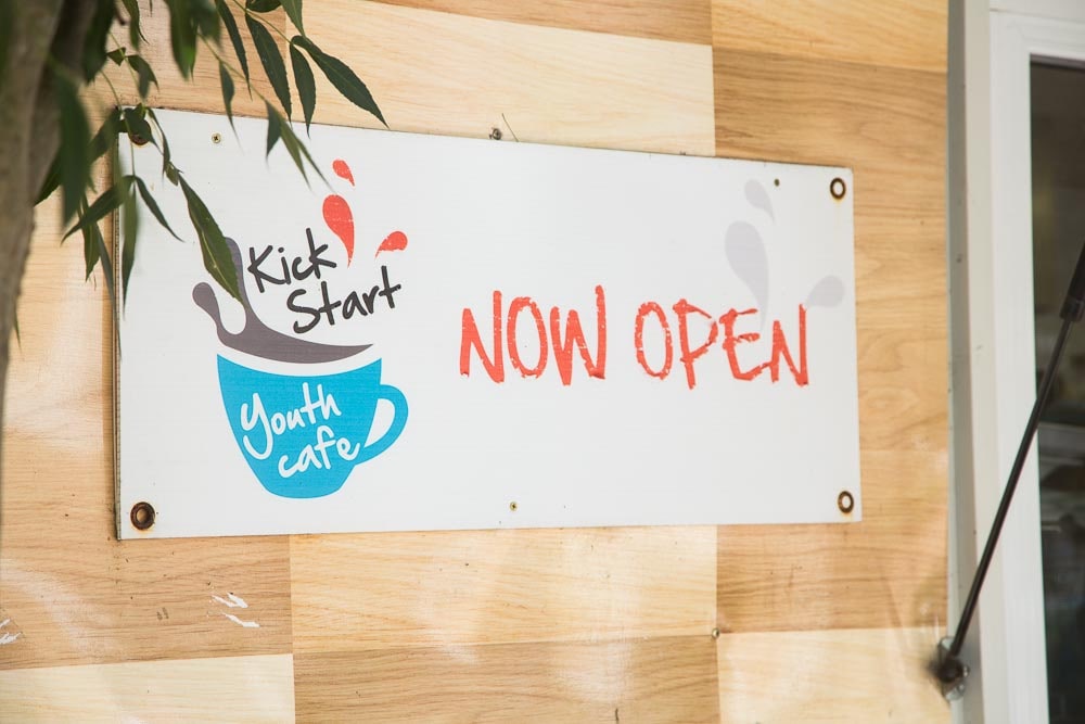 Wall sign that says Kick Start Youth Cafe, Now Open
