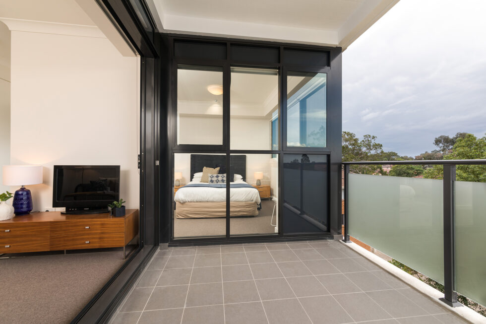 View into a furnished unit bedroom from the balcony