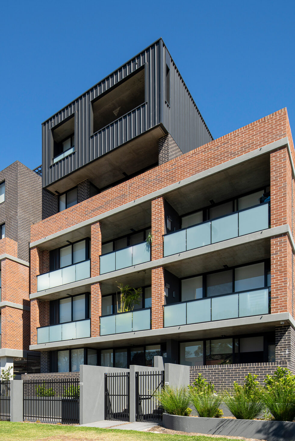 Five story building with gardens outside shown from footpath