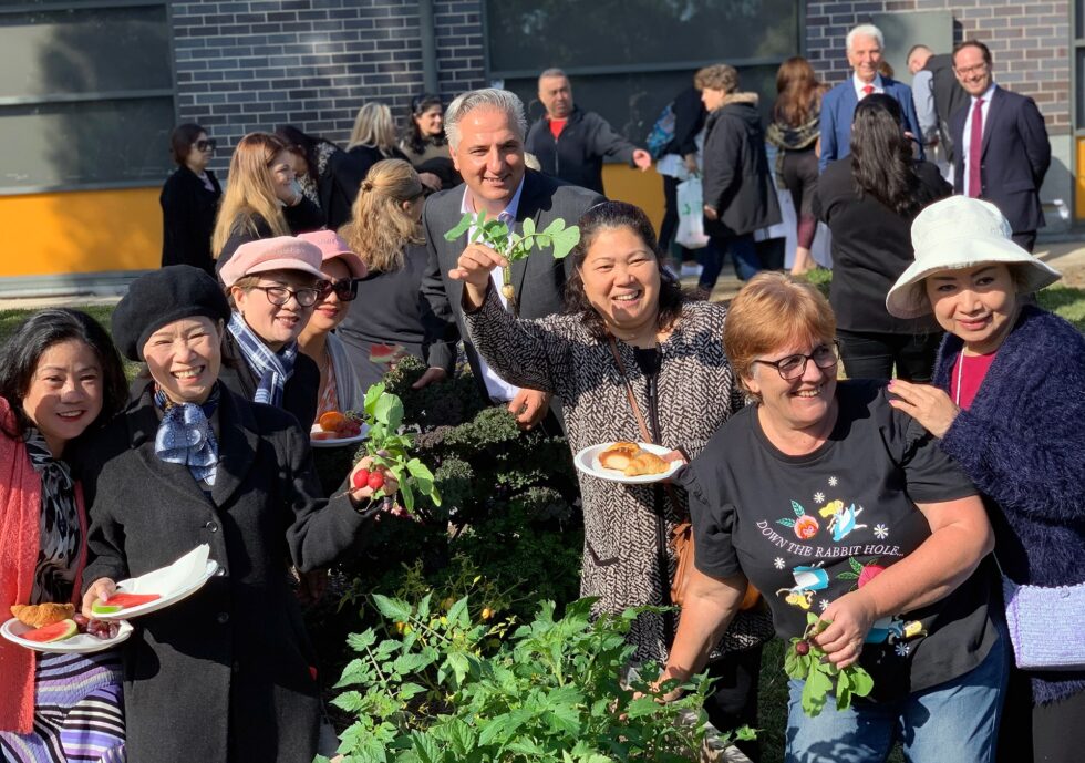 A group of customers eating morning tea and showing off garden at launch event
