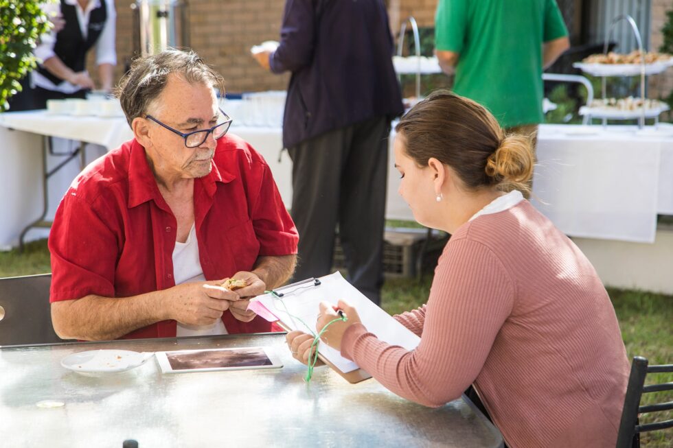 A tenancy manager filling out forms with a customer outdoors