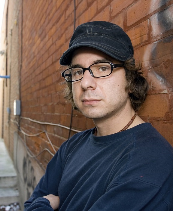 Serious looking young man standing in an alley