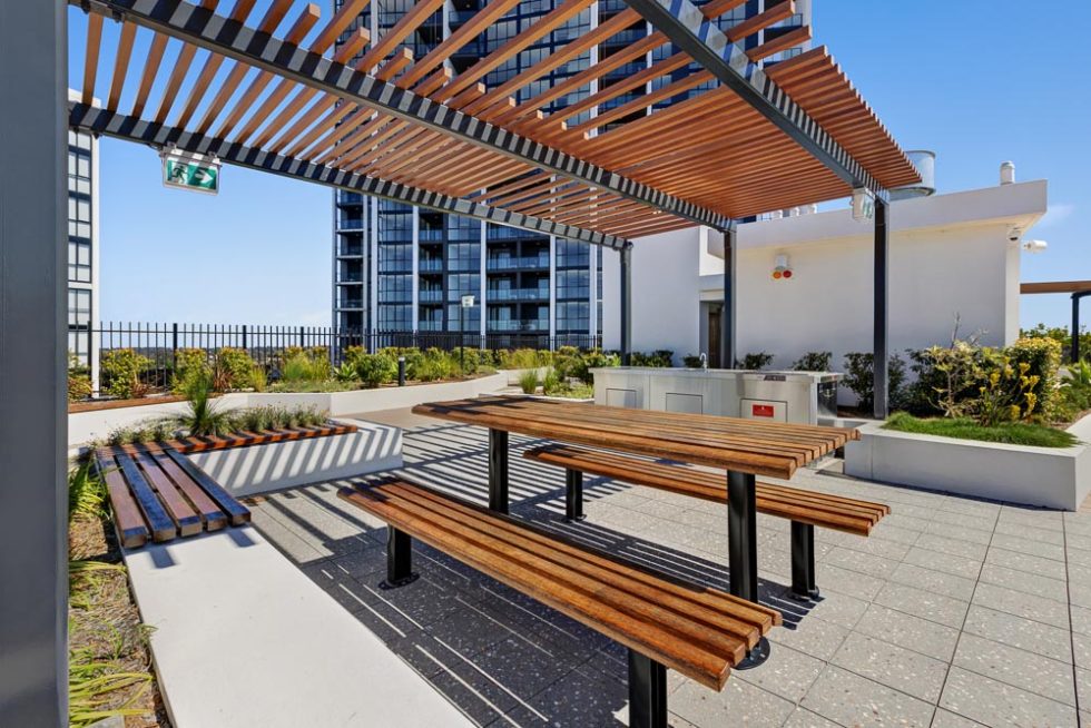 Rooftop entertainment area with garden and tables