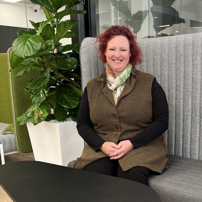 A woman sitting on an office couch smiling