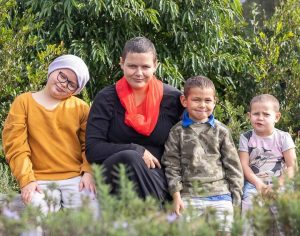 Mother and her three children sitting outside in the garden