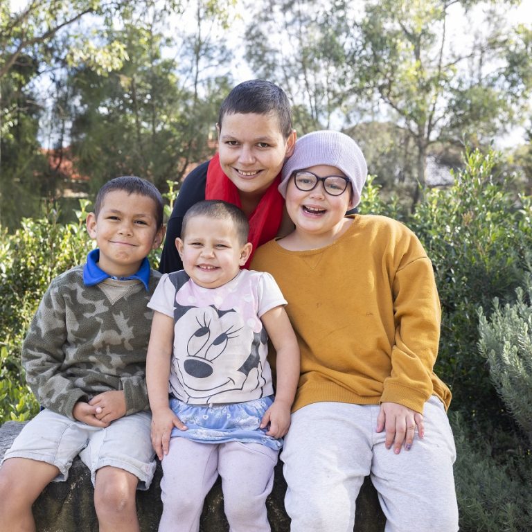 Mother and her three children sitting outside in the garden