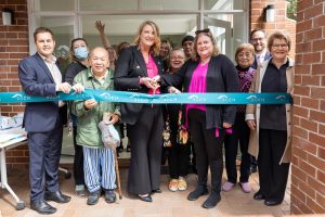 Kylea Tink, MP cuts the ribbon with residents and North Sydney Deputy Mayor William Burke (left) to officially re-open the community room