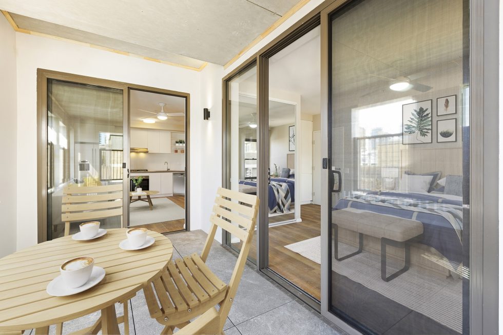 View of a furnished unit from the spacious balcony into the main bedroom one one side and lounge area on the other