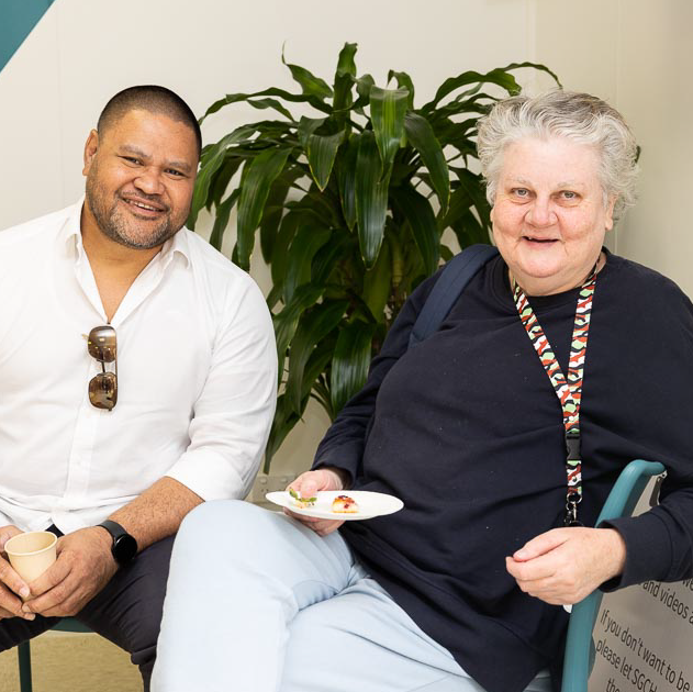A man and older woman sitting together having morning tea