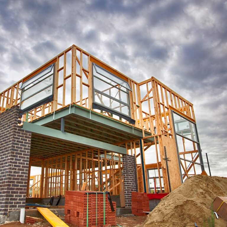 A two story house under construction in the wooden frame stage